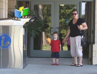 A woman takes a child to the book drop